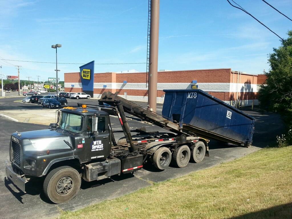 WTR Services roll-off truck delivering a commercial dumpster at a business in Northeast Ohio
